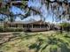 Backyard with a patio set, green grass, and Spanish moss hanging from the trees at 481 Belle Ayre Dr, Mount Dora, FL 32757