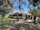 Cozy home featuring a quaint backyard patio with outdoor seating under a large umbrella, perfect for relaxing and entertaining guests at 481 Belle Ayre Dr, Mount Dora, FL 32757