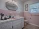 Retro pink-tiled bathroom featuring a white vanity and classic fixtures at 481 Belle Ayre Dr, Mount Dora, FL 32757