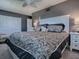 Bedroom featuring gray walls, ceiling fan, and a large patterned bed at 481 Belle Ayre Dr, Mount Dora, FL 32757