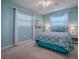 Charming bedroom with blue walls, white curtains, and a comfortable bed with decorative pillows at 481 Belle Ayre Dr, Mount Dora, FL 32757