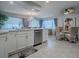 Bright kitchen featuring white cabinets, granite countertops, and an adjacent dining area with chandelier at 481 Belle Ayre Dr, Mount Dora, FL 32757