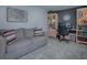 Living room with gray sofa, office desk, and bookshelf, with a decorative area rug at 481 Belle Ayre Dr, Mount Dora, FL 32757