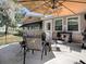 Outdoor patio featuring an umbrella, outdoor seating, and a grill at 481 Belle Ayre Dr, Mount Dora, FL 32757