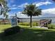 Waterfront property showcasing a private dock, boat house, and lush landscaping under a partly cloudy blue sky at 481 Belle Ayre Dr, Mount Dora, FL 32757