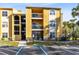 Condo with a yellow exterior, balconies, and well-maintained landscaping at 5255 Images Cir # 207, Kissimmee, FL 34746