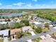 Aerial view of a community with several single-Gathering homes surrounded by trees and a pond at 5645 Huntington St, Leesburg, FL 34748