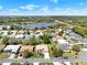 Aerial view of a community with several single-Gathering homes, lush greenery, and a pond at 5645 Huntington St, Leesburg, FL 34748