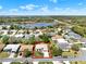 Aerial view of a community with several single-Gathering homes, lush greenery, and a pond at 5645 Huntington St, Leesburg, FL 34748