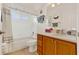 Bright bathroom features a shower-tub combo and a single sink vanity with wooden cabinetry at 5645 Huntington St, Leesburg, FL 34748