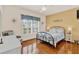 Cozy bedroom featuring hardwood floors, a ceiling fan, and natural light from shuttered windows at 5645 Huntington St, Leesburg, FL 34748