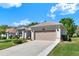 Charming single-story home with a well-maintained lawn, beige stucco, and two-car garage at 5645 Huntington St, Leesburg, FL 34748