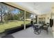 Relax on this screened porch featuring ample seating with a view of the lush green backyard at 5645 Huntington St, Leesburg, FL 34748