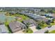 Aerial view showcasing a neighborhood with homes, green spaces, and a pond, creating a vibrant community at 5835 Hensley Ave, The Villages, FL 32163