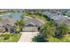 Aerial view showcases the home's prime waterfront location, mature palm trees, and well-maintained lawn at 5835 Hensley Ave, The Villages, FL 32163