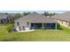 Aerial view of backyard with screened-in porch, patio, and grill overlooking green space at 5835 Hensley Ave, The Villages, FL 32163