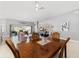 Dining room with wood table, seating for four, and views of the living room and outdoor patio at 5835 Hensley Ave, The Villages, FL 32163