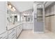 Main bathroom featuring double sinks, white cabinetry, a walk-in shower, and neutral decor at 5835 Hensley Ave, The Villages, FL 32163