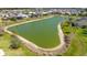 Scenic aerial view of a lush pond surrounded by residential homes, creating a tranquil and picturesque community at 5835 Hensley Ave, The Villages, FL 32163