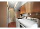 Functional laundry room featuring a full-size washer, dryer, and overhead cabinets at 603 N Lakeshore Blvd, Howey In The Hills, FL 34737