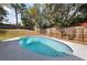 Inviting in-ground pool framed by a wooden fence and lush greenery at 603 N Lakeshore Blvd, Howey In The Hills, FL 34737