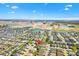 An aerial view shows the home's location with new construction and water features in the distance at 6088 Keckonen Dr, The Villages, FL 32163