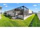 Exterior view of a screened in lanai surrounded by lush green grass in backyard at 6088 Keckonen Dr, The Villages, FL 32163