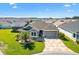 Charming single-story home with a well-manicured lawn, stone driveway, and inviting entryway at 6088 Keckonen Dr, The Villages, FL 32163