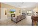 Inviting living room with neutral tones, tile flooring, ceiling fan, and seamless flow to dining area at 6088 Keckonen Dr, The Villages, FL 32163