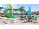 Community pool splash zone with tables, chairs, and colorful slides, perfect for Gathering fun and relaxation at 6856 Perch Hammock Loop, Groveland, FL 34736