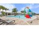 Modern community pool featuring a colorful splash zone with a slide, and lounge chairs for relaxing at 6856 Perch Hammock Loop, Groveland, FL 34736