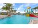 Large community pool featuring splash zone with play structure, surrounded by palm trees and lounge seating at 6856 Perch Hammock Loop, Groveland, FL 34736