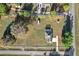 An aerial view shows the perimeter of the land parcel including the house, driveway, outbuildings, and trees at 7282 Se 24Th Ter, Bushnell, FL 33513