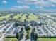 An aerial view of a community clubhouse, pool, and golf course on a sunny day at 9025 Se 136Th Loop, Summerfield, FL 34491