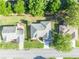 Aerial view of the house showing the roof, driveway, and surrounding trees at 9025 Se 136Th Loop, Summerfield, FL 34491