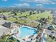 Aerial view showcases the pool and golf course amenities in a lush, green neighborhood at 9025 Se 136Th Loop, Summerfield, FL 34491