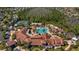 Overhead view of a community clubhouse with a pool, tennis courts, and lush surroundings at 906 Shady Canyon Way, Poinciana, FL 34759