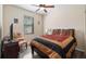 Cozy bedroom with a patterned chair, ceiling fan, and a window that provides natural light at 906 Shady Canyon Way, Poinciana, FL 34759