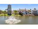 Stunning waterfront building with tower and fountain, complemented by manicured landscaping and lush trees at 906 Shady Canyon Way, Poinciana, FL 34759