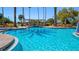 Sparkling community pool with plenty of lounge chairs and palm trees for relaxing at 906 Shady Canyon Way, Poinciana, FL 34759