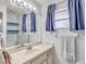 Bathroom featuring blue accents, large mirror and vanity, window and towel rack at 11414 Layton St, Leesburg, FL 34788