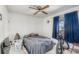 Simple bedroom with queen sized bed, bicycle and window with dark blue curtains at 11414 Layton St, Leesburg, FL 34788