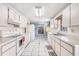 View of spacious kitchen featuring white cabinets and appliances, with tile flooring at 11414 Layton St, Leesburg, FL 34788