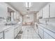 Efficient kitchen featuring bright white cabinets, white appliances and tiled floors at 11414 Layton St, Leesburg, FL 34788