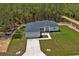 Aerial view displaying the home with a long driveway and spacious grassy yard surrounded by verdant trees at 12444 Sw 76Th Ln, Dunnellon, FL 34432