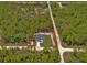 Aerial view showing the home situated on a lot surrounded by lush trees and a defined property boundary at 12444 Sw 76Th Ln, Dunnellon, FL 34432