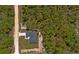 Overhead aerial view of a modern home situated on a spacious lot surrounded by dense trees, illustrating its seclusion at 12444 Sw 76Th Ln, Dunnellon, FL 34432