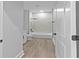 Bright bathroom featuring modern fixtures, a marble-tiled shower-tub, and sleek, light-toned wood flooring at 12444 Sw 76Th Ln, Dunnellon, FL 34432