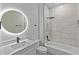 Bathroom featuring a modern vanity, backlit mirror, black hardware, with shower and tub combo with marble look tiles at 12444 Sw 76Th Ln, Dunnellon, FL 34432