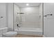 Modern bathroom showcasing a tiled shower-tub combination with sleek matte black fixtures, toilet, and light wood floors at 12444 Sw 76Th Ln, Dunnellon, FL 34432